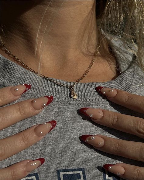 Red Almond Nails With Pearls, Red French Tip Nails Almond With Pearls, Pearl Nails With French Tip, Maroon Nails With Rhinestones, Red French Tip Nails With Diamonds, Red French Tips With Pearls, Red French Tips With Gems, Red French Tip With Pearls, Red French Tip Nails With Gems