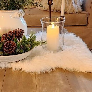 Sheila on Instagram: "Cozy time in the family room, and a view of the winter mantel 💫🕯️ As all the holiday decor gets stored, I've loved creating some winter spaces in my home. I've had several requests for how to style our homes this time of year. Here's a few ideas🤗 I'm keeping things simple, so I can transition into spring easily! I left a few of my favorite greenery picks and stems from Christmas out, along with a few pinecones, accents of gold, and faux fur textures on the table and sofa. Add your candlelight, light the fireplace, and enjoy! 🤗 The look is soft & fresh, especially with lighter neutral fabrics. I hope this inspires you to add a winter space to your home. Enjoy your night friend! #wintervignette #januarystyle #cozytimes #cozyhome #cozyhomedecor #winterstyle #winterma Faux Fur Rug Under Coffee Table, Natural Holiday Coffee Table, White Faux Fur Table Runner Christmas, Christmas Cottage Coffee Table, White Fur Christmas Decor, Neutral Fabrics, Winter Mantels, Holiday Deco, I Left