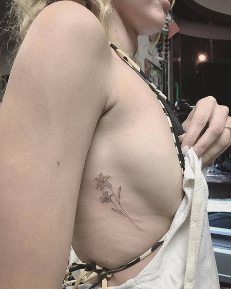 Single needle sideboob lily tattoo. Small Back Tattoos For Women Side, French Lily Tattoo, Dainty Lily Tattoo, Lilium Flower Tattoo, Single Lily Tattoo, Lily Tattoo Aesthetic, Single Needle Tattoo Ideas Women, Lily Side Tattoo, Lilly Spine Tattoo