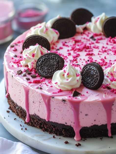 Ingredients:  For the crust:  - 2 cups Oreo crumbs - 1/4 cup unsalted butter, melted For the cheesecake: - 24 oz (680g) cream cheese, softened - 1 cup granulated sugar - 1 cup sour cream - 1 teaspoon vanilla extract - 3 large eggs - 2 tablespoons cocoa powder - 1 teaspoon pink food coloring - 1/2 cup crushed Oreos For the drip: - 1 cup white chocolate chips - 1/2 cup heavy cream For decoration: - Whipped cream - Mini Oreos - Pink velvet cake crumbs - Sprinkles Pink Cheesecake, Pink Velvet Cake, Mini Oreos, Pink Velvet Cakes, Dessert Hacks, Candy Birthday Cakes, Pink Food, Crushed Oreos, Pink Food Coloring