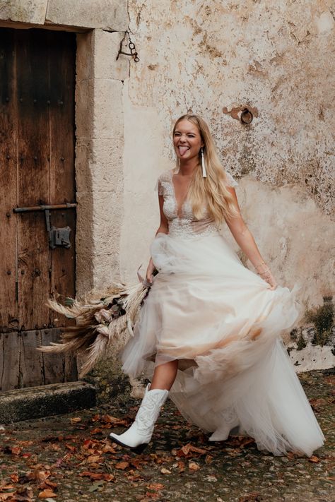 This fun bride paired all white cowboy boots with her flowy bridal gown | Image by Rosanna Lilly Photography Wedding Dress Cowboy Boots, Luxe Boho, Wedding Dress With Cowboy Boots, Vestidos Country, Dress With Cowboy Boots, Bride Boots, Divine Atelier, Wedding Cowboy Boots, Dresses With Cowboy Boots