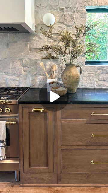 Mackenzie Craven on Instagram: "Probably my most FAQ. Our stone wall has been installed for just about a year now and I couldn’t love it more 🫶🏻

Floor & Decor Alamo Sandstone Random Ledger Panel" Stone Backsplash Wood Cabinets, Stone Backsplash Kitchen Black Counter, Stone Backsplash Black Cabinets, Wood Cabinets Stone Backsplash, Stone Wall Tiles Kitchen, Stone Backsplash Kitchen Dark Cabinets, Stone Backsplash Black Countertop, Alamo Sandstone Random Panel Ledger, Stone Wall Kitchen Backsplash