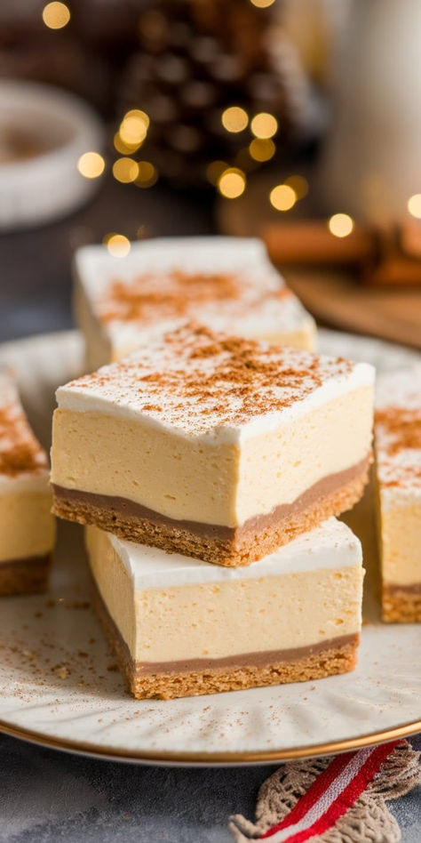 Treat your taste buds to these Eggnog Cheesecake Bars! With a buttery crust and rich, spiced filling, they’re a deliciously festive twist on classic cheesecake that everyone will love this season. Egg Nog Cheesecake Bars, Mulled Wine Cheesecake, Eggnog Cheesecake Bites, Mini Eggnog Cheesecake Recipe, Best Eggnog Cheesecake Recipe, Eggnog Cheesecake Bars, Eggnog Cheesecake With Gingersnap Crust, Eggnog Desserts Christmas, Cheesecake Bars Christmas