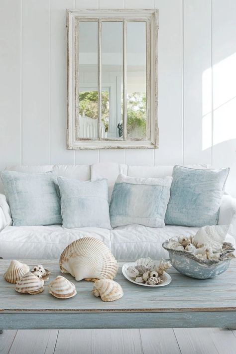 A cozy living room beautifully blends coastal and vintage decor styles, highlighting an inviting atmosphere. This pin captures the charm of mixing distressed wood textures with ocean-inspired tones. Neutral Coastal Living Room, Vintage Beach Cottage, Distressed Sideboard, Antique Pendant Light, Coastal Artwork, Interior Design Games, Vintage Nostalgia, Unique Products Design, Coastal Living Room