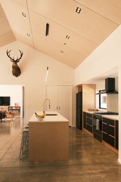 The bespoke inset kitchen was tailor-made for a contemporary rural residence in Waikanae. Utilising natural birch 18mm/13ply Birch Elite plywood from PlyTech, paired with matte black surfaces in Futura HPL, brings a sleek and modern vibe to the area. The meticulous attention to detail shines through in the ceiling panelling, crafted from 12mm Birch Elite plywood with a white-washed finish, elevating the kitchen's overall look. #CustomKitchen #BirchPlywood #ModernDesign #RuralHome. Ceiling Panelling, Plywood Walls, Dark Floors, Modern Vibe, Custom Kitchen, Birch Plywood, White Wash, Future House, Kitchen Interior