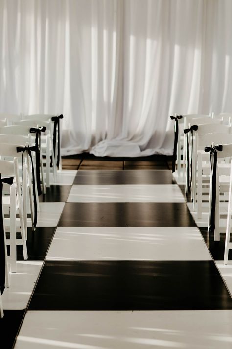 Black and White Wedding Dance Floor in Check Pattern Black And White Aisle Decor, Bow Aisle Markers, Bows On Ceremony Chairs, Black Chairs Wedding Ceremony, Black White Minimalist Wedding, Ceremony Isle Ideas Indoor, Wedding Aisle Bows, Wedding Ceremony White Chairs, Black Bow Wedding Decor