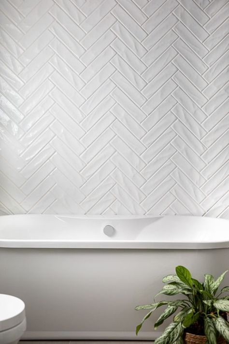 Herringbone Shower Tiles, White Herringbone Tile Fireplace, Backsplash Behind Freestanding Tub, Tiled Wall Behind Freestanding Tub, White Herringbone Fireplace Surround, Herringbone Tile Bathtub Wall, Herringbone Bathroom Wall Tile, Herringbone White Tile Bathroom, Tile Behind Bathtub