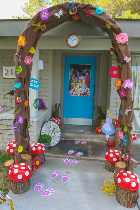 Down the Rabbit Hole and into Wonderland...  This was the entrance to my daughter's Alice in Wonderland themed party.  I re-purposed an old wedding arch and covered it in brown fabric, colorful flowers, and butterflies to create the rabbit hole.  Tree stumps from our backyard topped with "mushroom caps"  created larger than life toadstools.  You can even see the white rabbit left his footprints behind...Oh Mr. Rabbit!!! Alice In Wonderland Rabbit, Deco Disney, Alice In Wonderland Tea Party Birthday, Mad Hatter Party, Alice In Wonderland Birthday, Wedding Arch Flowers, Arch Decoration Wedding, Alice In Wonderland Theme, Alice In Wonderland Tea Party