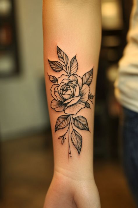 Black and gray rose tattoo on person's forearm. Simple Rose Tattoo Forearm, Rose Daisy Tattoo, Black Work Flower Tattoo, Dalia Flower Tattoo, 3 Roses Tattoo Design, Camellia Flower Tattoo, Blooming Flower Tattoo, Floral Wrist Tattoo, Unique Rose Tattoo