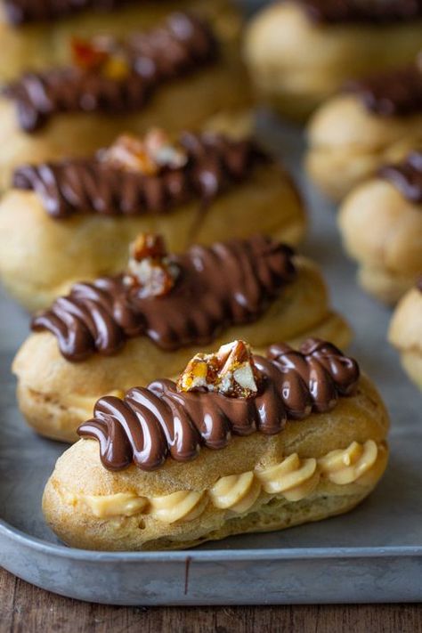 Chocolate eclairs with salted caramel custard and pecan brittle | The Food Fox Pecan Brittle, Chocolate Eclairs, Caramel Custard, Choux Buns, Eclair Recipe, Chocolate Eclair, Baking Desserts, Caramel Frosting, Custard Filling