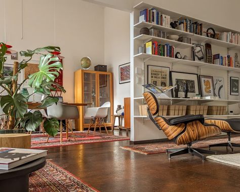 How This Renter Turned a “Repurposed Classroom” into a Stunning Home Loft Apartment Mid Century, Eclectic Living Room Wall Shelves, Renter Friendly Bookcase Wall, Entry Into Living Room, Artists Loft Apartment, Living Rooms With Tv, Industrial Loft With Plants, Loft Wall Decor, Bedroom Storage Boxes