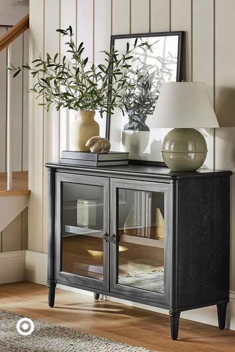 Add freshness to your entryway with beige & gray tones—faux greenery, decorative marble accents & a compact storage cabinet make the spring vibes really pop at home. How To Decorate A Sideboard, Change Of Seasons, Salon Suites, Cabinet Black, Faux Greenery, Door Glass, Studio Mcgee, Display Storage, Glass Cabinet