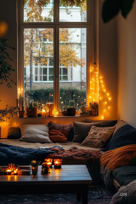 Cozy fall living room with candles, pillows, and string lights by the window. Fall room decor creates a warm and inviting atmosphere indoors. Warm Fall Decor, Amber Lighting, Warm Color Palettes, Room Cozy, Living Room Loft, Chunky Knits, Warm Colour Palette, Cozy Autumn, Small Space Gardening