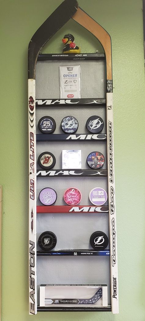 Hockey Puck Shelf, Hockey Stick Hat Rack, Hockey Collage Ideas Pictures, Ice Hockey Themed Bedroom, How To Display Hockey Pucks, Hockey Themed Basement, Hockey Shadow Box Ideas, Hockey Jersey Display Ideas, Hockey Puck Display Diy