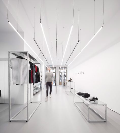 this streetwear store in porto portugal sets the stage for the minimalist clothing it offers. diogo aguiar studio designed the space with straight rigid lines in order to accentuate the store’s high ceilings and expansive length. one gets the impression of a much larger space. Clothing Store Design, Retail Lighting, Retail Interior Design, Interior Minimalista, Retail Store Design, Boutique Interior, Dark Interiors, Retail Interior, Store Design Interior