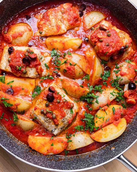 Baccala alla Napoletana is a traditional Italian dish that is best known in America for its appearance in the Feast of the Seven Fishes lineup on Christmas Eve. Salt cod, also known as baccala, is cooked in a garlicky tomato sauce with olives, capers, and potatoes. #baccala #italianfood #sevenfishes #seafood Baccala Recipes Italian, Italian Fish Dishes, Bacala Recipe, Italian Christmas Eve Dinner Traditional, Bacalao Recipe, Italian Fish Recipes, Cod Stew, Feast Of The Seven Fishes, Sip And Feast