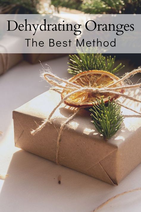 A dehydrated orange slice on a kraft paper-wrapped gift with twine as ribbon, the title reads "dehydrating oranges, the best method" Dehydrated Fruit For Decor, Dehydrated Fruit Gift Ideas, How To Dry Fruit For Decorations, Dehydrated Fruit Decorations, Dehydrated Gifts, Dehydrated Orange Slices Decoration, Drying Orange Slices, Cake Wrapping Ideas, Dehydrate Oranges