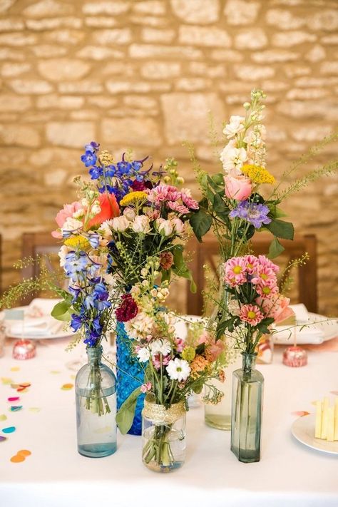 mixed bottles and wildflower wedding centerpiece ideas Wildflower Wedding Centerpieces, Wildflower Centerpieces, Wedding Theme Color Schemes, Wildflower Wedding Theme, Wedding Centerpieces Mason Jars, Laid Back Wedding, Bridal Shower Cakes, Wedding Table Flowers, Mason Jar Wedding