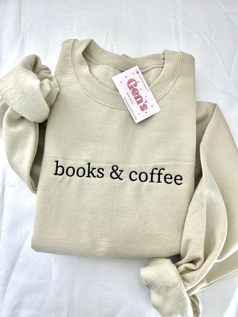 "Wrap yourself in literary comfort with our \"Books And Coffee\" embroidered sweatshirt, a must-have for every book lover in the Reading Crew. This minimalist book sweatshirt, the perfect Book Club Gift, seamlessly blends cozy warmth with bookish flair, making it an essential addition to your stylish reading ensemble. Color in example is Sand  * 50% cotton, 50% polyester * Pre-shrunk * Classic fit * 1x1 athletic rib knit collar with spandex * Air-jet spun yarn with a soft feel and reduced pillin Book Sweatshirts, Bookish Sweatshirts, Minimalist Book, Books And Coffee, Bookstore Cafe, Gemini And Aquarius, Bookclub Gifts, Lover Sweatshirt, Screenprinting