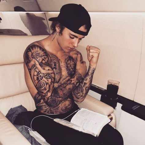 Singer-songwriter Justin Bieber's latest proclamation of his Christian faith is a photo he posted to his Instagram account over the weekend. It shows him sitting down on an airplane seat, shirtless, with an open Bible on his lap. Bieber Tattoos, Justin Bieber Tattoos, Man With Tattoos, Bieber Fever, Love Justin Bieber, Justin Bieber, Sleeve Tattoos, Tattoo Designs, Men's Fashion