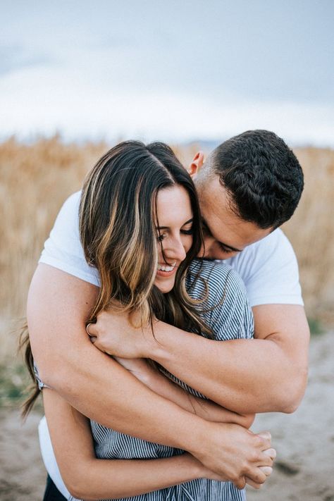 Romantic summer night Utah blue lake engagement photoshoot couple session Utah photographer blue dress beach clothes #utahphotographer #engagements #beach #engagementsession #coupleshoot #couplesession #weddingphotographer arms wrapped around corn husks tall grass Blue Dress Beach, Utah Lake, Couples Beach Photography, Couple Beach Pictures, Couple Beach Photos, Lake Photoshoot, Utah Lakes, Photoshoot Couple, Lake Engagement