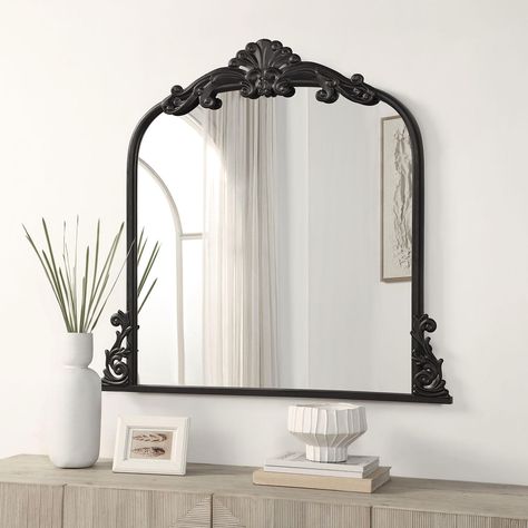 The Azalea Park Filigree Wall Mirror will add elegance to any room. This product features a glass mirror and a frame which is made from iron and built to last. The frame has luxurious details around the border with two filigree motifs on the sides of the product with one center piece on the top. The mirror comes in two finishes: an antique gold or matte black.This vintage inspired product is perfect for above a console table, mantel or dresser. It’s also a great option for a vanity mirror to cre Entryway Mirror And Table Small Entry, Mirrors Over Fireplace Mantle, Foyer Mirror Ideas Entry Ways, Mantel Mirror, Above Nightstand Decor, Fireplace Mirror Ideas, Mirror Over Fireplace, Foyer Mirror, Nursery Mirror