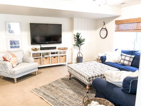 Navy and white basement  makeover with a nautical feel. Bamboo shades, Denim sofa, Blue and white striped side chair. Ikea furniture  #shiplapwalls #shiplapbasement #basementmakeover #whitewallsbasement #blueandwhitebasement #beachcottgefamilyroom #beachcottage #casualcottagedecor #basementideas Nautical Basement Ideas, Nautical Basement, White Basement, Fabric Coffee Table, Denim Sofa, Vertical Shiplap, Basement Reno, Basement Makeover, Bamboo Shades