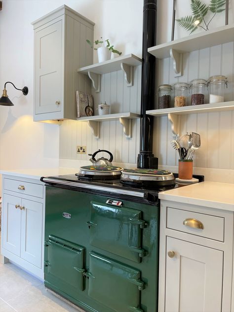 In frame kitchen design featuring a stunning racing green Aga, which is surrounded by tongue and groove panelling and open shelving. Aga Backsplash, Wales Cottage, Kitchen Aga, Green Aga, Scotland House, Kitchen With Open Shelving, Aga Kitchen, Aga Stove, Shaker Kitchens