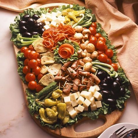 An antipasto platter that is a colorful presentation of cheese, vegetables and meats, sure to be a focal point of any appetizer buffet table.