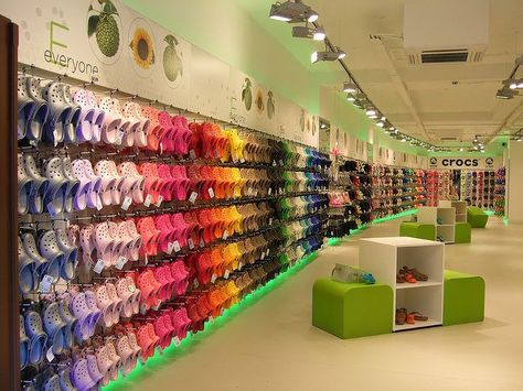 This store layout uses the technique of dominance by color. They did this by hanging all the crocs, along the wall, by color. This is a technique in merchandising that is very effective in grabbing the attention of the shopppers. "People buy color! Color is what sells!" Shelf Merchandising, Nana Shoes, Interactive Retail, Crocs Store, Sock Display, Fashion Store Design, Shoe Store Design, Cute Store, Crocs Fashion