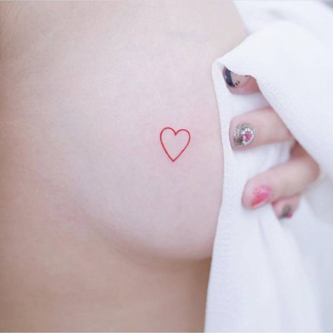 Minimalist red heart tattoo on the breast. Red Heart Hip Tattoo, Small Heart Chest Tattoo Female, Red Heart Between Chest Tattoo, Red Heart Tattoo On Bum Cheek, Small Red Heart Tattoo On Buttcheek, White Heart Tattoos, Red Heart Tattoos, Explore Tattoo, Red Tattoos