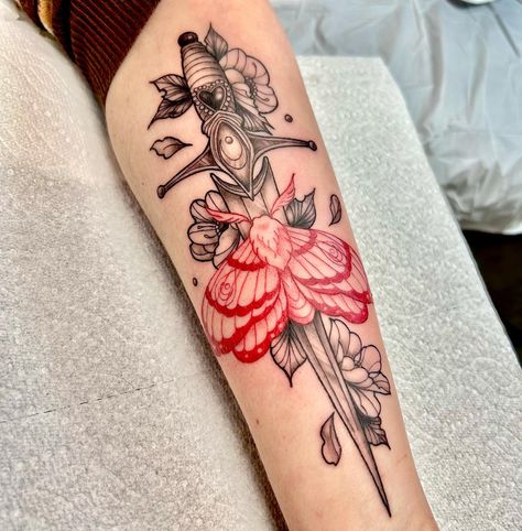 Unlock the allure of mystery and elegance with @colleenajsmith's signature black and red moth tattoo, adorned with a dagger and surrounded by delicate florals. Each detail, a symphony of beauty and danger, intricately woven in ink to captivate and inspire. 🦋🗡️🌺 Dagger Back Tattoo Women, Black And Red Moth Tattoo, Dagger Moth Tattoo, Red Moth Tattoo, Knife With Flowers Tattoo, Moth And Dagger Tattoo, Floral Dagger Tattoo, Moth To A Flame Tattoo, Shooter Tattoo