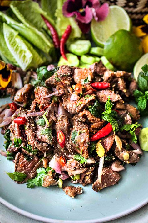 This authentic Thai beef larb recipe is a super tasty and popular dish from Isaan (Northeastern )Thailand. It's a flavorful salad made with near-raw, thinly sliced beef. This tasty Thai larb has a wonderful assortment of fresh herbs that bring out the bold, addictive flavors. It's an easy recipe, and it's extra healthy! #beeflarb #beeflaab #beeflarbrecipe #authenticbeeflarb #thailarb #thailaab #thailaabrecipe #authenticlaabrecipes Thai Food Salad, Spicy Beef Salad Thai, Thai Laab Recipe, Nam Tok Beef Salad Recipes, Thai Chicken Larb, Beef Larb Recipe Thai, Thai Beef Marinade, Larb Recipe Thai Authentic, Laab Salad Recipe