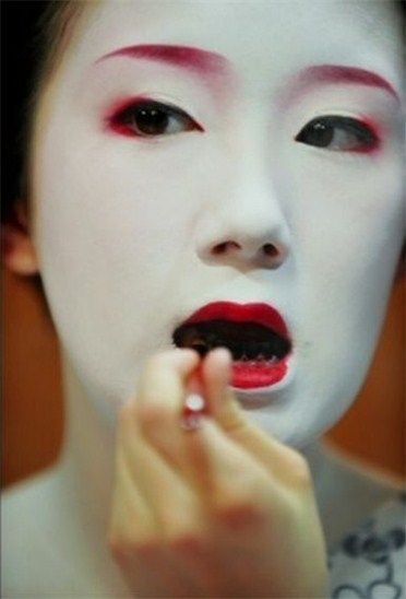 This is a maiko (apprentice geisha) blackening her teeth for her debut as a geiko (geisha). During the heian era, this practice was done for cosmetic and health reasons. The teeth were more protected from decay, and it was more beautiful than having yellowing teeth with white face powder.  Geisha continue the practice for special ceremonies if they wish. Geisha Makeup, Black Teeth, Heian Era, Ancient Japan, Memoirs Of A Geisha, Modern Pictures, Japanese Geisha, Japan Culture, First Tooth