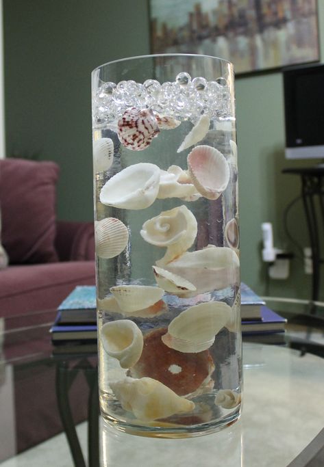 seashells suspended in clear water beads Vase With Clear Water Beads, Water Theme Centerpieces, Gel Water Beads, Orbeez Decorations Ideas, Water Beads Ideas Diy Floating Candles, Clear Water Beads Centerpiece Ideas, Water Beads Ideas Decor, Orbeez Decor, Water Beads Crafts