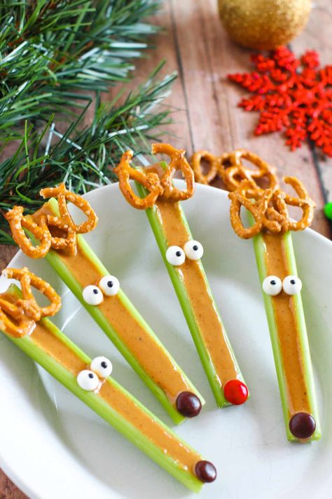 These cute reindeer celery sticks will turn your afternoon snack into a fun holiday treat. Crunchy peanut butter-filled celery sticks are transformed into adorable reindeer with the addition of pretzel antlers, M&M noses, and candy eyes. Getting your kids to eat a healthy snack has never been easier, and they can even help you make it! Celery Reindeer, Peanut Butter Celery, Christmas Snacks Easy, Xmas Goodies, Fun Holiday Treats, Candy Eyes, Pinterest Food, Celery Sticks, Peanut Butter Snacks