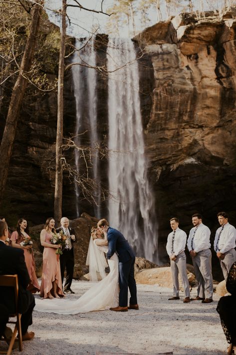 Bride and Groom share their first kiss in front of Toccoa Falls in Georgia. Wedding Venues Waterfall, Wedding At Waterfall, Toccoa Falls Georgia Wedding, Overlook Wedding Ceremony, Intimate Wedding Locations, Tocca Falls Georgia Wedding, Water Fall Wedding Ideas, Fall Wedding Locations, Waterfall Wedding Ceremony