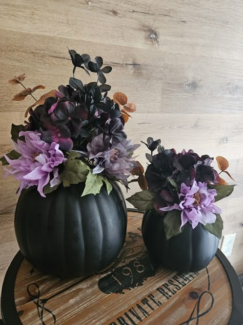 Spruce up your home  with witchy halloween flower arrangements inside of pumpkins. These pumpkins feature spooky tones that are sure to create a fun environment this season. Filled with Hydrangea, Copper Eucalyptus, Lavender Dahlia, Dark Grey Dahlia These pumpkins are made using trending fall colors, and are perfect for decor in baby showers, weddings, centerpieces, or any other party.  Due to variation in flower arrangements and sprays, each pumpkin is truly unique, and my not look exactly like the one pictured. Please remember that our pumpkins sell very fast. We may not always have enough supplies to remake them. Don't delay in getting yours now! Please note that during peak times our shipping dates may be extended without notice, but we will always do our best to ship within the time f Halloween Floral Bouquet, Black Pumpkin Centerpiece, Spooky Baby Shower Centerpieces, Dollar Tree Halloween Flower Arrangements, Cauldron Flower Arrangement, Spooky One First Birthday Centerpieces, Bat Centerpieces, Black Pumpkin Ideas, Gothic Floral Arrangements