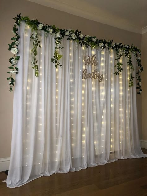 Floral And Lights Backdrop, Curtain Flower Backdrop, Light Backdrop Diy, Backdrop With Flowers And Lights, Natural Backdrop Ideas, Curtain Flowers Decor, Fairy Light Curtain Backdrops, Baby Shower Backdrop Flowers, Greenery Backdrop With Lights