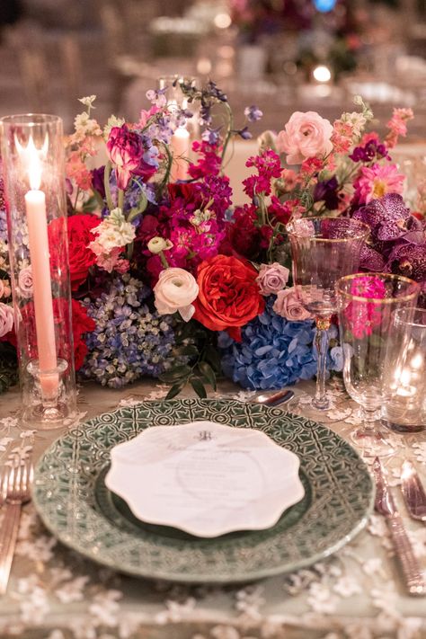 Bold and bright tablescape featuring jewel-toned florals, elegant green plates, and crystal glassware. Bright Tablescape, Floral Tablescape, Floral Table Setting, Colorful Table Setting, Head Table Wedding, Jewel Tone Wedding, Green Plates, Tablescape Ideas, Reception Inspiration