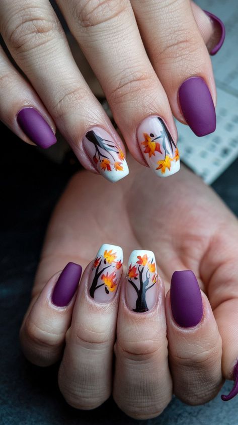 Embrace the beauty of fall with these stunning nail designs! Featuring a rich purple matte finish paired with delicate autumn leaves and trees, these nails capture the essence of the season. Perfect for cozy sweater weather or a chic night out. Get inspired to bring the colors of autumn to your manicure! #septembernails #fallnails Purple And Gold Fall Nails, Thanksgiving Nails Purple, Autumn Purple Nails, Purple Thanksgiving Nails, Fall Tree Nail Designs, Purple Pumpkin Nails, Autumn Nails Purple, Purple And Orange Nail Designs, Purple Fall Nails Design