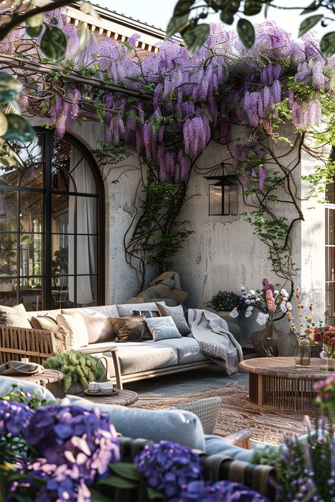 Cascade of Wisteria • A verdant living tapestry drapes elegantly over the pergola, wisteria blooms in a vibrant cascade of lavender • Beneath, a plush array of cushions and throws adorn the outdoor sofa, inviting leisurely afternoons • Time stands still in this tranquil alcove, where rustic charm meets refined comfort • The laughter of blooms and whispers of leaves create a melody, while the soft glow of natural light completes this picturesque retreat. House With Wisteria, Pergola Wisteria, Nature Backyard, Wisteria Pergola, Cushions And Throws, Time Stands Still, Wildflower Garden, Backyard Inspo, Cozy Nook