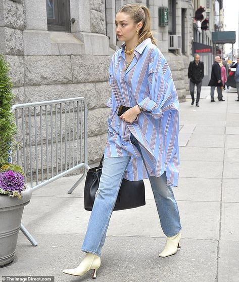 Off she goes: She complemented the top with a pair of fashionably faded jeans and balanced... Shirt Oversize, Classic Oversized Denim Tops, Elegant Oversized Blue Shirt, Oversized Denim Blue Cotton Shirt, Oversized Long Sleeve Denim Blue Shirt, Oversized Washed Denim Button-up Top, Oversized Shirt Outfit, Oversized Striped Shirt, Gigi Hadid Street Style