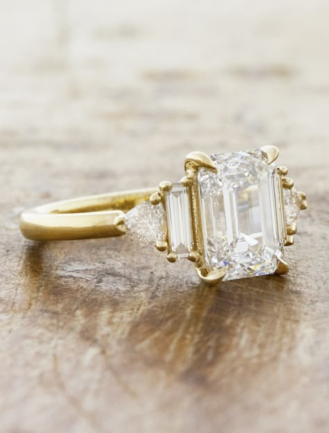 Nicolette is a masterpiece of modern sophistication and timeless elegance. At its core, a breathtaking emerald-cut diamond exudes a sleek, refined brilliance. Flanking the center stone are two trillion-cut diamonds and vertical baguette side stones adding a unique geometric allure. Interested in seeing wedding band pairings? Check out some options here. Setting only cost below: 14k Rose, White, or Yellow Gold setting $3,300 18k Rose, White, or Yellow Gold setting $3,600 Platinum setting $3,900 2 Carat Emerald Cut Engagement Ring Yellow Gold, Emerald Cut Ring Sets, Emerald Cut Wedding Ring And Band, Rose Gold Engagement Ring Diamond, Gold Diamond Baguette Ring, Tiffany Engagement Ring Emerald Cut, Timeless Diamond Engagement Rings, Simple Gold Engagement Rings Emerald, Emerald Center Stone Engagement Ring