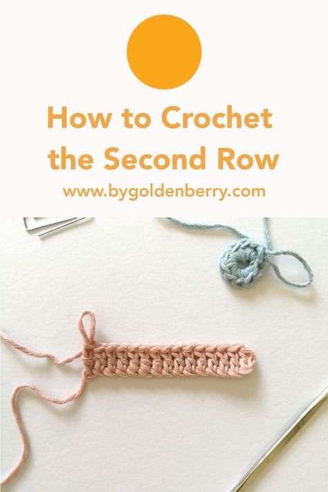 A photo of one row of crochet in pastel pink and a small one row round crochet project in baby blue yarn. The background is off white. Above the image is orange text which reads "How to Crochet the Second Row". "www.bygoldenberry.com" and an orange circle above the text. Single Crochet Second Row, How To Crochet Rows For Beginners, How To Start 2nd Row Crochet, How To Crochet For Beginners Second Row, 2nd Row Crochet, How To Start Next Row Crochet, Starting Second Row Crochet, How To Start A New Line In Crochet, How To Crochet Rows