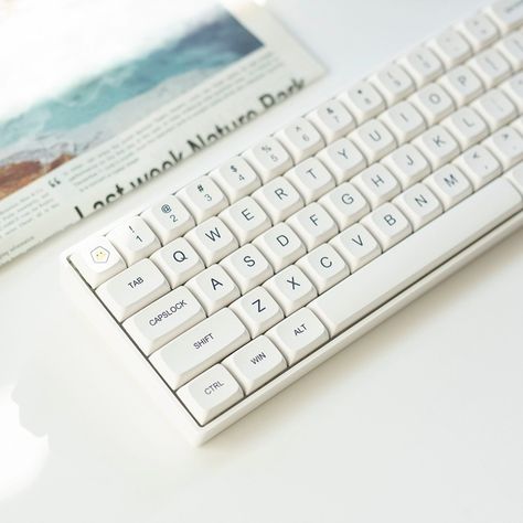 Please accept this white minimalism. Different from the cliche black, this white is clear, natural, fresh, and clean. It is undoubtedly an excellent match for typing or gaming, allowing you to isolate all impurities and focus on this moment on the keyboard only. #minimalist #white #keycap #keycaps #keycapset #mechkeyboard #mechkeyboards #officelife #officespace #officedecor #pcsetup #gamingsetup #gamingsetups #gamingsetupidea #keyboard #keycapss Fancy Keyboard, Key Cap, Key Caps, Minimalist White, Ipad Stand, Pc Setup, Gaming Setup, Fresh And Clean, This Moment