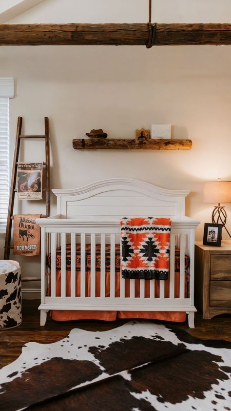 Western-themed nursery with white crib, rustic wooden beams, cowhide rug, and southwestern decor. Western Boho Nursery Girl, Baby Girl Nursery Western, Western Theme Nursery Boy, Western Boho Nursery, Western Baby Boy Nursery, Western Nursery Ideas, Cowboy Themed Nursery, Western Baby Nursery, Vintage Cowboy Nursery