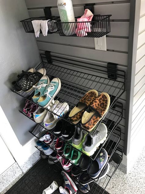 A mudroom, also known as an entryway where you can sit, take off your shoes and coat, can become an additional space in the garage just for you and your family. This is a relatively cost-effective way to vamp up your garage while also transforming it to be more functional. Bringing in a bench, a coat rack and some organizational slatwall baskets or shelves is all that is needed to create a mudroom suitable for easy storage and functionality. #mudroom #garagemudroom #homeorganization #garage Shoes Storage Garage, Wall Mounted Shoe Storage Garage, Garage Shoe And Coat Storage, Slatwall Mudroom, Garage Shoe Storage Wall Shelves, Shoe Storage Garage Entry, Garage Coat Rack Ideas, Shoe Organizer For Garage, Shoes In Garage Storage Ideas