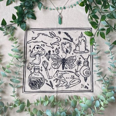 milzbe on Instagram: "🍂🥀witches cauldron top 🥀🍂 • • • #smallbusiness #smallbusinessuk #smallbusinessowner #smallbusinesssupport #witchcraft #witch #witchesofinstagram #witchaesthetic #rabbit #cottagecore #cottagestyle #frog #frogart #linoprint #linoprinting #linocutprint #lino #linocutting #etsy #etsyuk #etsysellersofinstagram #etsyseller #depop #depopseller #halloween #halloweendecor #halloween🎃 #halloweenart" Rabbit Cottagecore, Cottagecore Cow, Witch Tshirt, Mushroom Frog, Cottagecore Mushroom, Mushroom Shirt, W.i.t.c.h Aesthetic, Lino Art, Spooky Tattoos