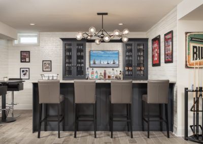 Northwoods Sports Themed Basement Bar - Thyme & Place Design Basement Sports Bar Ideas, Basement Bar With Tv, Bar With Tv, Basement Sports Bar, Transitional Basement, Basement Bar Plans, Bar Plans, Custom Light Fixtures, High Top Tables